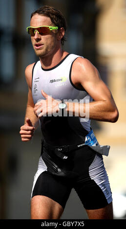 Il pilota di Formula uno Jenson Button corre nella terza fase durante il Mazda London Triathlon, presso l'Excel Centre di Docklands, East London. Foto Stock