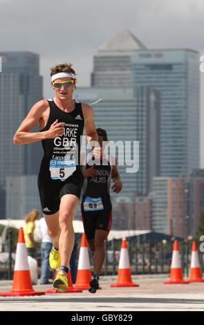 La Great Britain's Will Clarke passa accanto a Canary Wharf sulla strada per la vittoria nella gara Men's Elite durante il Mazda London Triathlon, presso l'Excel Center di Docklands, nella zona est di Londra. Foto Stock