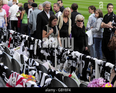 Lady Elsie Robson (occhiali scuri), la vedova di Sir Bobby Robson, è unita da altri membri della famiglia, mentre guardano le migliaia di tributi a suo marito che sono stati lasciati a St James Park, la casa di Newcastle United, nel corso del fine settimana. Foto Stock