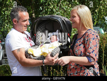 Thomas Cook protester Avril Boyne e il suo partner Ian Mahon (a sinistra) con il loro neonato Chelsea fuori dal Coombe Maternity Hospital, Dublino. Foto Stock