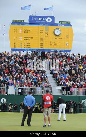 Tom Watson (a sinistra) degli Stati Uniti e il suo caddio Neil Oxman (al centro) guardano avanti mentre Stewart Cink (a destra) degli Stati Uniti gioca il suo colpo finale per vincere l'Open il quarto giorno del Campionato Open al Turnberry Golf Club. Foto Stock