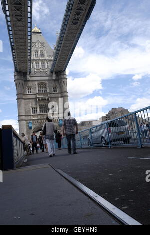 I turisti a piedi sotto la passerella aerea presso il Tower Bridge City of London Foto Stock
