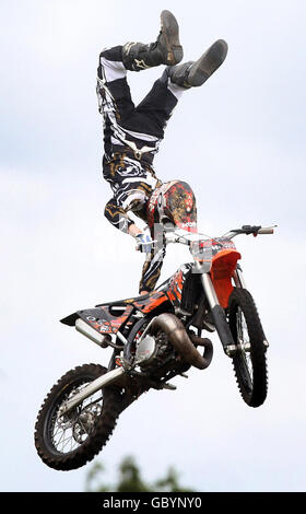 Un pilota di UKFMX, un team di stunt Freestyle Moto-Cross, esegue uno stunt al Glasgow Show, a Glasgow Green. Foto Stock