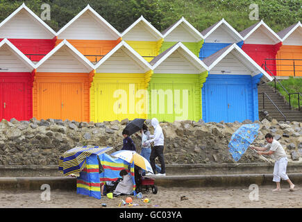 Turisti in forte pioggia e forti venti sulla spiaggia di Scarborough. Il Met Office aveva previsto un agosto piovoso, opposto alla sua dichiarazione precedente in aprile, quando ha emesso una previsione stagionale che ha suscitato speranze per un'estate calda e soleggiata con un'affermazione che il Regno Unito era 'a caso per un'estate barbecue'. Foto Stock