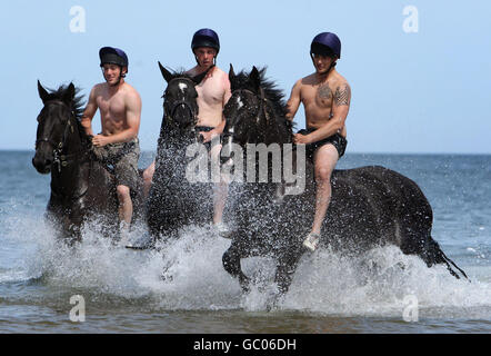 Le truppe della Household Cavalry montato regiment esercitare i loro cavalli in mare, al largo di Holkham Beach, a Holkham, Norfolk come iniziano il loro annuale Regimental Training. Foto Stock