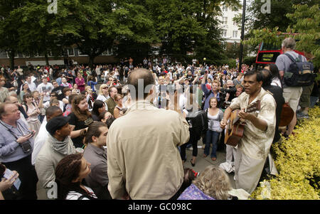 I membri del pubblico attraversano la famosa Zebra attraversando fuori Abbey Road Studios a St John's Wood, a nord di Londra, durante una ricreazione della copertina dell'album Beatles Abbey Road per celebrare il 40° anniversario dell'album. Foto Stock