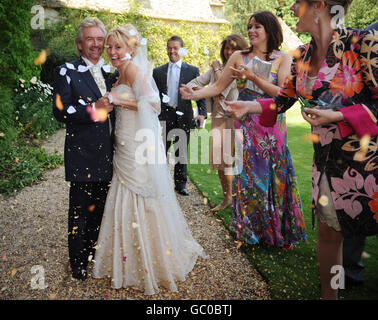 L'ospite della TV Noel Edmonds e sua moglie Liz Davies fuori dalla chiesa di St Mary nella Lower Slaughter, Gloucestershire, dove erano sposati. Foto Stock