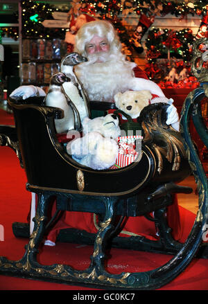 Un paio di pinguini Humboldt aiutano 'Santa Claus' ad aprire ufficialmente Harrod's Christmas World a Knightsbridge. Foto Stock