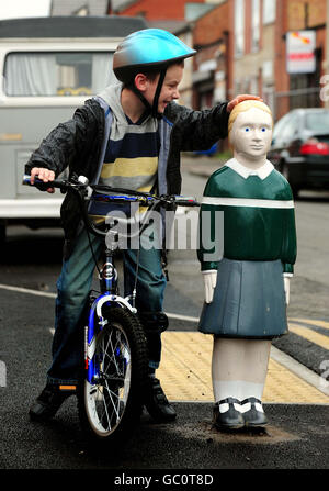 Bradley Ward, 8 anni, di Leicester, con un bollard fatto apparire come un bambino fuori Avenue Primary School a Leicester. Foto Stock