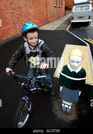 Bradley Ward, 8 anni, di Leicester, con un bollard fatto apparire come un bambino fuori Avenue Primary School a Leicester. Foto Stock