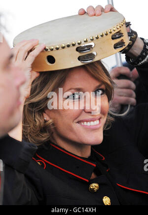 Cerys Matthews si rifugia dalla pioggia sotto un tamburello prima di dare un concerto ai racegoisti dopo la corsa nel giorno ufficiale di apertura a Ffos Las. Foto Stock