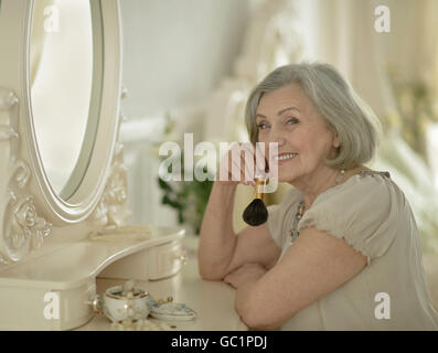 Senior donna con make up pennello Foto Stock