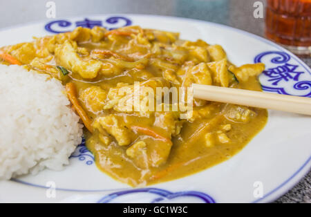 Cinese di pollo in salsa di arachidi, servito con riso e hot salsa rossa Foto Stock