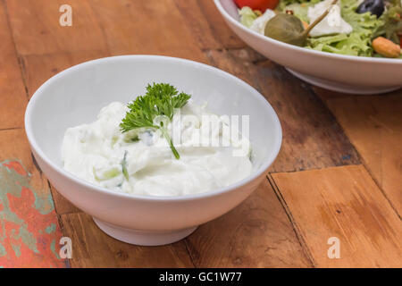 Tzatziki greco guarnite con prezzemolo su una tavola di legno Foto Stock