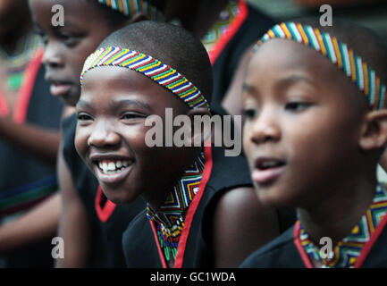 I bambini della African Children's Choir aiutano la cantante Annie Lennox a svelare un memoriale a Nelson Mandela, dove la pietra reca l'iscrizione della Fondazione 46664 per la beneficenza degli aiuti di Nelson Mandela, fuori dalle Camere della città di Edimburgo. Foto Stock