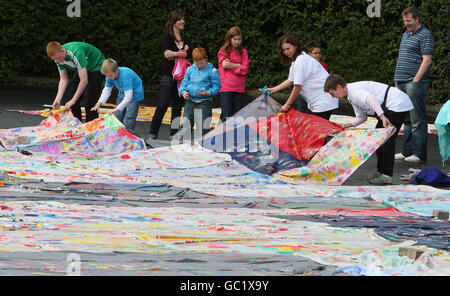 Bambini e adulti prendono parte a un tentativo di battere il record mondiale per la pittura delle dita, a Belfast. Foto Stock