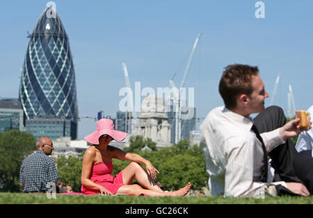 La gente si siede al sole nel Potters Field Park, Londra, mentre il Sud Est crogiolarsi sulla scia di un'onda di calore continentale. Foto Stock