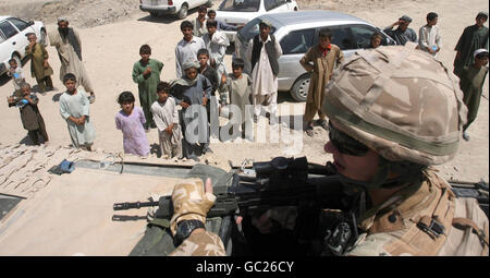 2° LT Andrew Chalmers del 40° Reggimento l'artiglieria reale passa una folla durante una pattuglia a Lashkar Gah, Afghanistan. Foto Stock