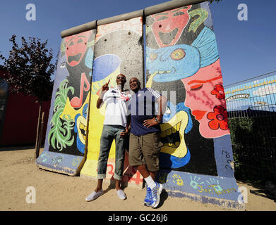 Il grande britannico Phillips Idowu pone con il suo allenatore Aston Moore, per i media al muro di Berlino dopo aver tenuto una conferenza stampa su un autobus turistico all'aperto durante i Campionati del mondo IAAF all'Olympiastadion, Berlino. Foto Stock