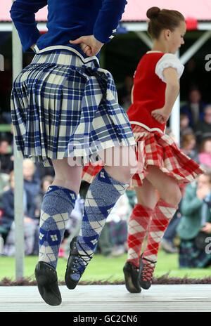 I concorrenti si esibiscono durante gli Highland Games di Braemar, Scozia. Migliaia di abitanti del luogo, turisti e appassionati reali si radunano ogni anno per assistere ai tradizionali eventi degli Highland Games, tra cui il tiro del cabino e un rimorchiatore di guerra. Foto Stock