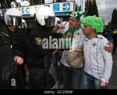 I tifosi dell'Irlanda del Nord condividono una battuta con la polizia polacca fuori dallo stadio prima della partita di qualificazione europea della Coppa del mondo allo Slaski Stadium di Chorzow, Polonia. Foto Stock