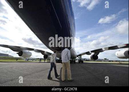 La gente cammina sotto la sezione di coda del velivolo di prova MSN1, un Airbus A380 Superjumbo jet, siede all'aeroporto di Filton, Bristol in attesa di partire per Tolouse, Francia, dopo un giro intorno all'Europa e al Regno Unito dove si stima che un milione di persone si sono rivelate vedere l'aereo. Foto Stock
