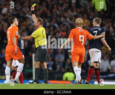 Calcio - Coppa del mondo FIFA 2010 - turno di qualificazione - Gruppo nove - Scozia / Olanda - Hampden Park. L'arbitro Claus Bo Larsen (seconda a sinistra) mostra Robin van Persie (a sinistra) dell'Olanda una carta gialla dopo aver fouling Scotland's Darren Fletcher (a destra) Foto Stock