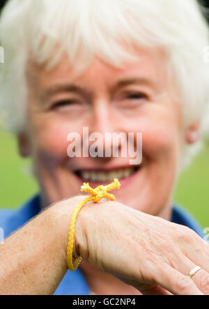 Personalità televisiva ed ex-avvocato Margaret Mountford lega un 'Forget Me Knot' per mostrare il suo sostegno per i consorzi di carità 'Ricordati DI UNA Charity's Forget Me Knot Week'. Foto Stock