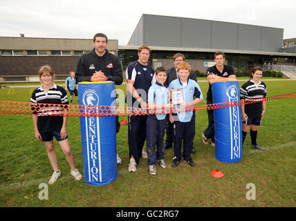 Tim Visser e Jim Hamilton di Edinburgh Rugby posano con gli studenti per una foto di gruppo con Gavin Hamilton di Currie e Clint Lanyon mentre mostrano la loro targa Scottish Widows Bank Rugby Champions Scheme durante il lancio del nuovo campo da rugby alla Currie High School di Edimburgo. Foto Stock