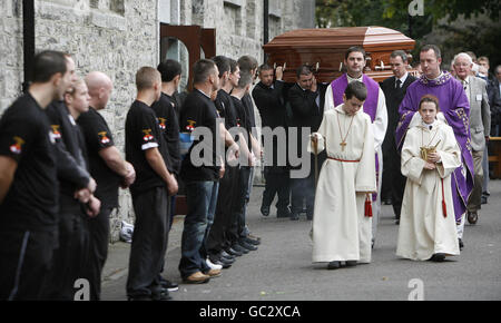 I pugili dell'accademia olimpica di pugilato di St Saviors formano una guardia d'onore mentre la bara di Darren Sutherland viene portata dalla chiesa di St Mary in Navan, dopo il servizio funerale. Foto Stock