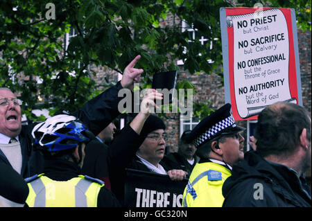 I gruppi di protesta agita cartelli e gridano mentre le reliquie di Santa Teresa di Lisieux lasciano York Minster oggi dopo la loro visita. Foto Stock