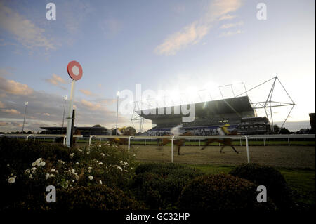 Corridori e piloti passano il posto vincitore e tribuna nel Midland Facilities Management E.B.F. Maiden Fillies' Stakes presso l'ippodromo di Kempton Park. Foto Stock