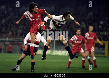 Il Dean Saunders di Liverpool salta per la palla, guardato dai compagni di squadra Ray Houghton, seconda a destra, e Mark Wright, durante la partita della Coppa UEFA del quarto turno contro Genova. Foto Stock