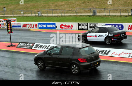 Un pilota si prepara a gareggiare contro una polizia britannica Subaru Impreza WRX, che si è beffata come una macchina di polizia statunitense, durante 'Beat the Heat' alla Santa Pod Race Way, Wellingborough, Northamptonshire. Foto Stock