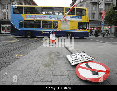 Un autobus di Dublino passa la scena di un incidente passato tra un autobus a due piani (non mostrato) e un tram Luas su o'Connell Street. Foto Stock