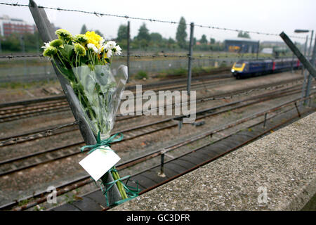 Un primo treno del Great Western si avvicina a Londra quando i fiori sono lasciati dai sopravvissuti e dalle famiglie in cattività che sono venuti a celebrare il decimo anniversario dell'incidente ferroviario di Paddington, a Ladbroke Grove, nella parte ovest di Londra. Foto Stock