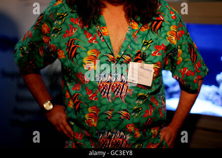 L'espositore Tim Haye nella sua camicia di pesce accanto agli acquari della mostra "Fish Antics" nel terreno del RDS Dublin durante PET Expo 2009 che mostra tutti i tipi di specie e prodotti. Foto Stock