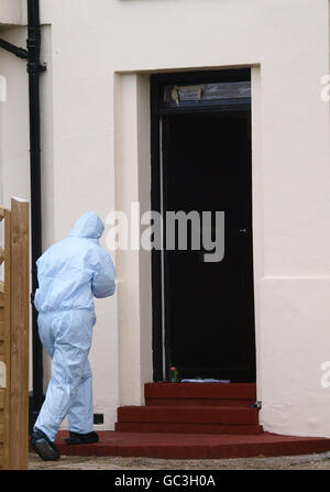 Un esperto forense della polizia cammina verso l'ingresso di una casa a Edgware, a nord di Londra, durante un raid della polizia su un piccolo blocco di appartamenti. Report non comprovati hanno affermato che il raid era su una fabbrica di meths cristallo. Foto Stock