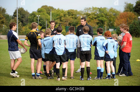 Tim Visser (a sinistra) e Jim Hamilton parlano agli studenti durante il lancio del nuovo campo di rugby alla Currie High School di Edimburgo. Foto Stock