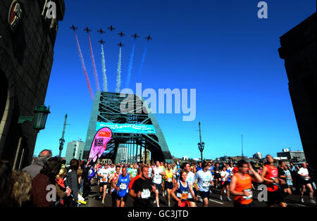 I corridori gareggiano nella corsa del nord grande del BUPA mentre le frecce rosse volano sopra a Newcastle. Foto Stock