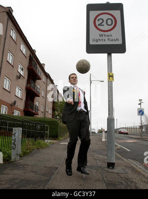 Il candidato alla SNP David Kerr calcia un calcio nelle strade della zona di Milton a Glasgow, mentre aiuta a lanciare la campagna di by-elezione di Glasgow Nord Est. Foto Stock