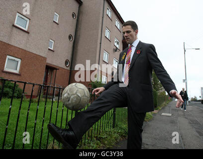 Il candidato alla SNP David Kerr calcia un calcio nelle strade della zona di Milton a Glasgow, mentre aiuta a lanciare la campagna di by-elezione di Glasgow Nord Est. Foto Stock