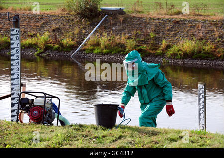 Un lavoratore dell'Agenzia dell'ambiente tratta il fiume Trent a Yoxhall, Staffordshire, dopo che è stato contaminato con acque reflue e cianuro non trattati. Foto Stock