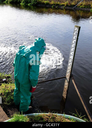 Un lavoratore dell'Agenzia dell'ambiente tratta il fiume Trent a Yoxall, Staffordshire, dopo che è stato contaminato con fognature e cianuro non trattati. Foto Stock