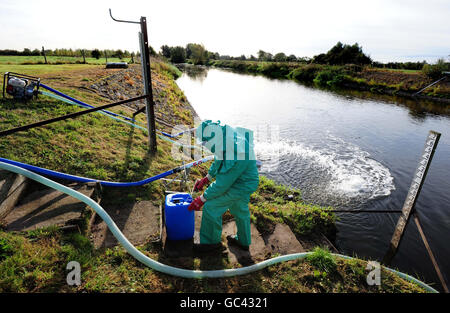 Un lavoratore dell'Agenzia dell'ambiente tratta il fiume Trent a Yoxall, Staffordshire, dopo che è stato contaminato con fognature e cianuro non trattati. Foto Stock