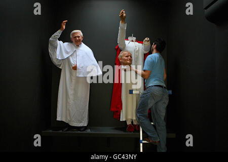 Danny Balan solleva la testa di cera di Papa Giovanni Paolo II in posizione accanto alle opere di cera dell'attuale Papa Benedetto XVI mentre si preparano i preparativi finali per l'apertura ufficiale del riaperto National Wax Museum Plus a Foster Place, Dublino. Foto Stock