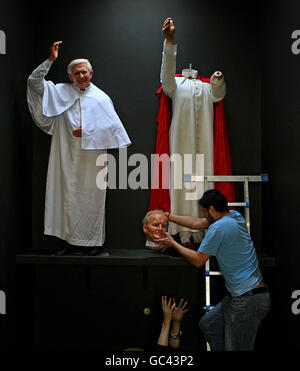 Danny Balan solleva la testa di cera di Papa Giovanni Paolo II in posizione accanto alle opere di cera dell'attuale Papa Benedetto XVI mentre si preparano i preparativi finali per l'apertura ufficiale del riaperto National Wax Museum Plus a Foster Place, Dublino. Foto Stock