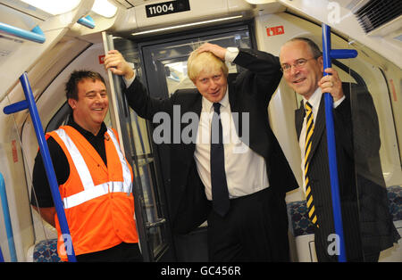 Sindaco di Londra Boris Johnson (centro), Peter Hendy (a destra), boss di TfL e TfL SQE Support Worker Colin Fair, a bordo di un treno T2 presso il deposito della metropolitana di Northumberland Park, dopo che sono stati fatti annunci relativi ai nuovi treni T2 e modifiche al sistema della zona di congestione. Foto Stock