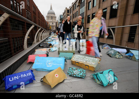 Gli escursionisti passano centinaia di tende in miniatura "fugee" sul Millennium Bridge, Londra, da un artista commissionato da Oxfam, Hermann Josef Hack, per evidenziare la campagna dell'agenzia internazionale per gli aiuti per esercitare pressioni sui capi di Stato e di governo dell'UE, attualmente in discussione, per 35 miliardi di euro all'anno in aiuti ai paesi più colpiti da cambiamenti climatologici. Foto Stock