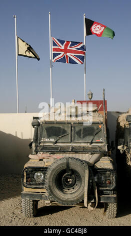 Le bandiere volano a metà palo presso la base operativa principale britannica per la Task Force Helmand a Lashkar Gah, Afghanistan. Foto Stock